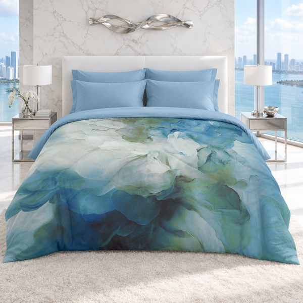 Blue Petals comforter in a bright-white modern Miami suite with matching powder-blue pillows and folded sheet, marble walls, and a city-water view