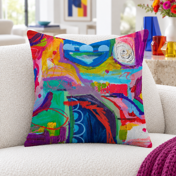 Destination Happiness pillow close-up in a white living room with colorful glass accents