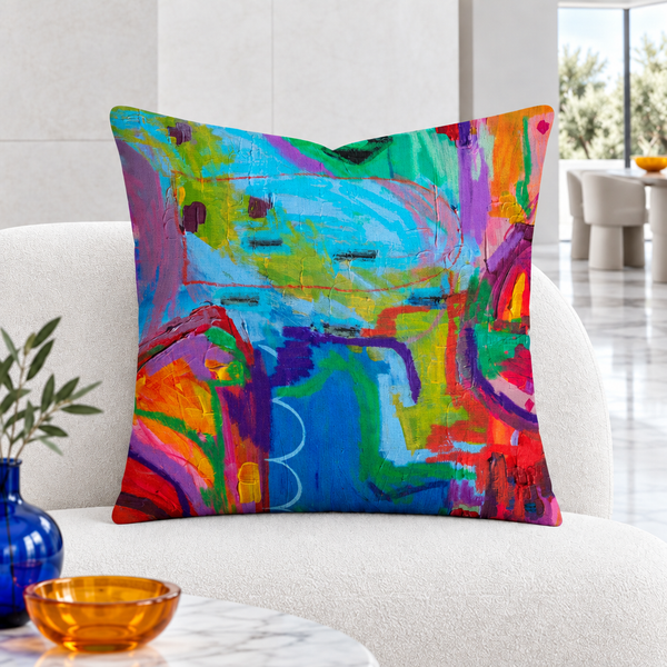 Closer view of the multicolor Destination Happiness pillow in a bright white gallery lounge with marble floor