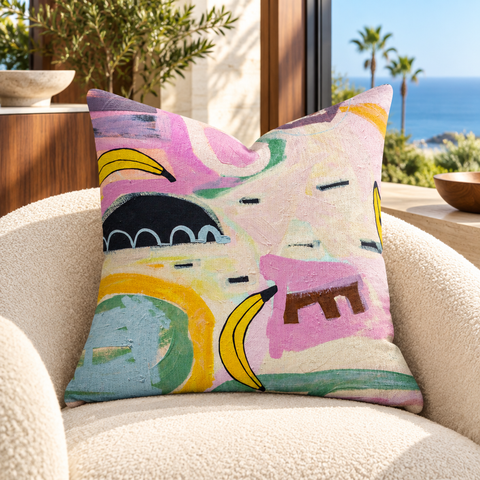 Going Bananas - 2 art pillow on an ivory chair in a Malibu sunroom