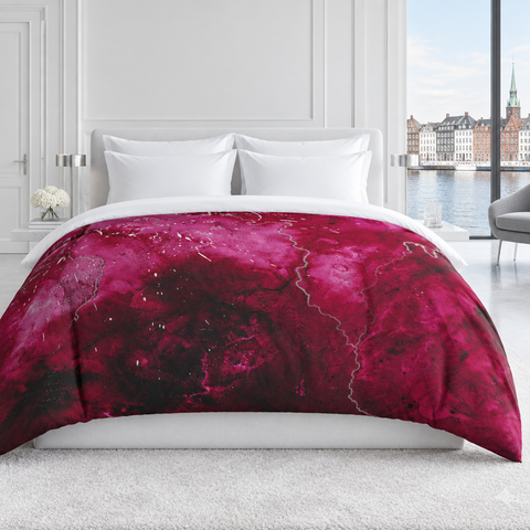 Raspberry comforter in a cool-white luxury Copenhagen room